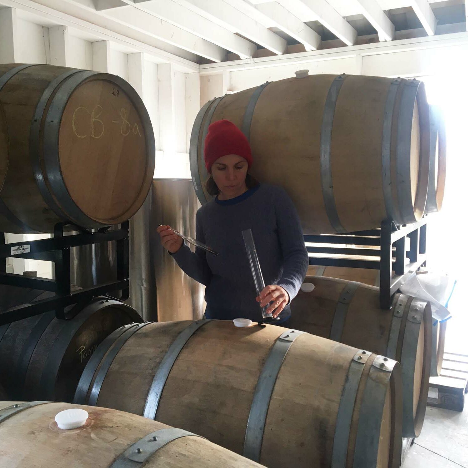 Autumn Stoscheck of Eve's Cidery, among barrels at the cidery. Credit: Ezra Sherman.